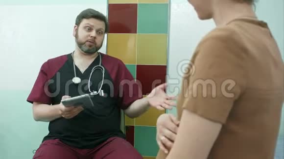 快乐的医生用数码平板电脑与孕妇共诊视频的预览图