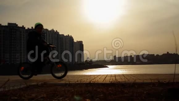 一个男孩在公园里骑自行车的剪影视频的预览图