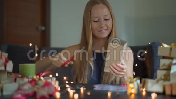 一个年轻女人的慢镜头正在包装礼物现在用工艺纸包裹着红色和金色的丝带视频的预览图