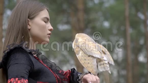 一只浅棕色的猫头鹰在森林中女人的手上展开翅膀视频的预览图