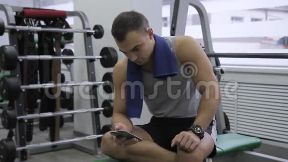一名运动员在现代体育馆进行磨合训练时正在用他的智能手机视频的预览图
