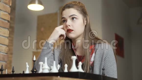 小女孩在下棋的时候考虑下一步的动作视频的预览图