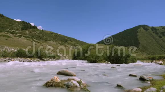 山地河流在背景高地和绿色田野上的山谷中流动视频的预览图