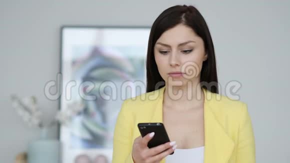 严肃的女人在讨论在智能手机上聊天视频的预览图