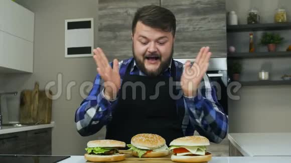胖子吃东西喜欢他的汉堡包有胡子的人吃他做的食物不健康的生活方式油炸和高视频的预览图