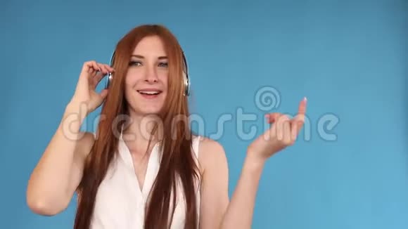 乔维亚年轻的女人一边跳舞一边听耳机里的音乐视频的预览图