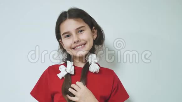 害羞的小笑着快乐的女孩站着可爱的少女快乐的女孩在白色背景下害羞情感是大孩子视频的预览图