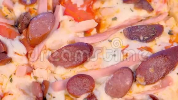 带熏香肠火腿和奶酪的披萨特写俯视图视频的预览图