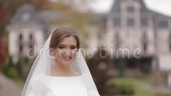 把漂亮的新娘关在外面穿着优雅的婚纱扮成摄像机的迷人女人视频的预览图
