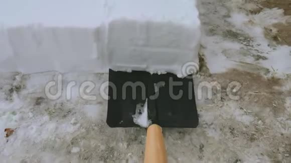 人从小路上铲雪暴风雪过后用雪铲从人行道上除雪小雪团视频的预览图