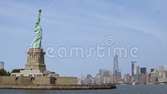 在晴朗的夏日自由女神像纪念碑的全景与令人惊叹的纽约市天际线背景视频的预览图