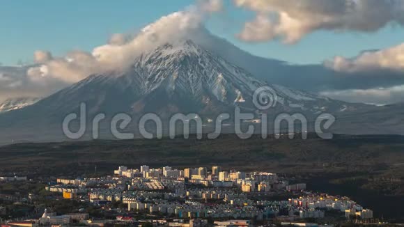 在天空和火山飘过的背景云上俯瞰城市景观视频的预览图