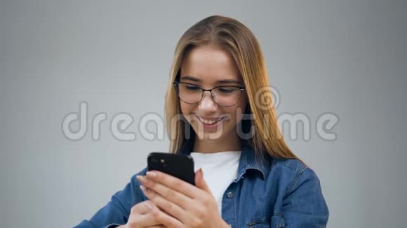 漂亮的年轻女人在办公室里用智能手机视频的预览图