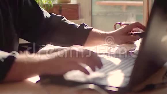 男性手在家里用笔记本电脑工作模糊的双手专注于背景上的一杯茶自由职业者视频的预览图