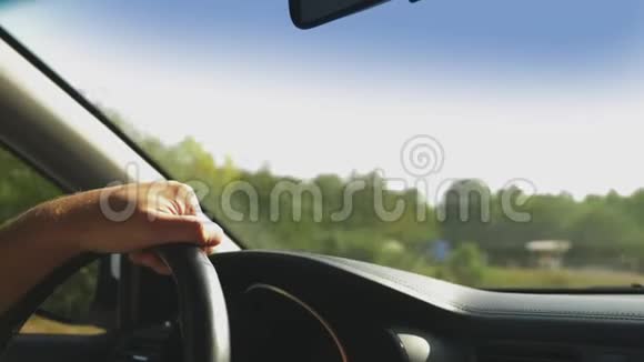 开车的人开着车大自然男性手在方向盘上关闭阳光眩光4k慢动作视频的预览图