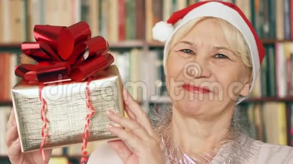 有礼物的高级女人戴红帽子带红丝带礼盒的退休人员庆祝圣诞节视频的预览图