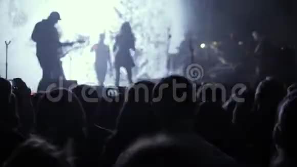 在摇滚音乐会上的人群聚会手拿着数码相机在摇滚音乐会的妇女中视频的预览图