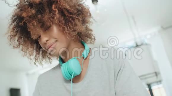 美国年轻快乐的非洲女人戴着耳机摆着相机视频的预览图