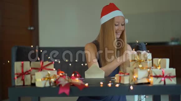 一个年轻女人的慢镜头正在包装礼物现在用工艺纸包裹着红色和金色的丝带视频的预览图