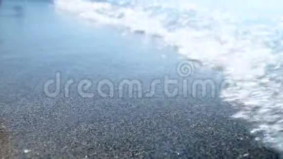 阳光明媚的一天4k特写视频显示温和的海浪在沙滩上奔跑海滩上的蓝色清澈的水提出摘要视频的预览图