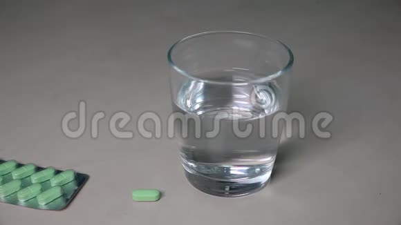 男性手把药丸和杯水放在木制背景上特写吃药视频的预览图