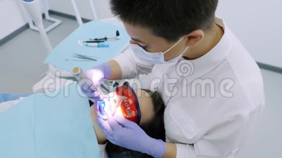 女士在牙科医生办公室用紫外线机器进行紫外线美白视频的预览图