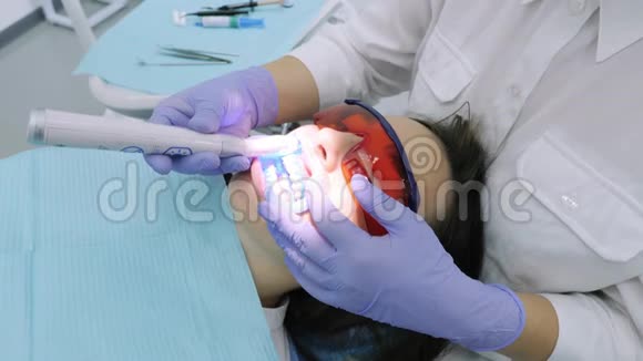 女士在牙科医生办公室用紫外线机器进行紫外线美白视频的预览图