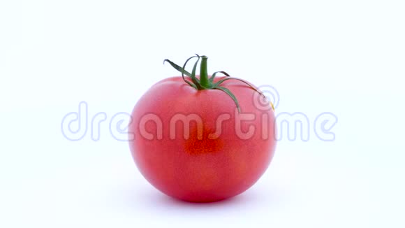 一整个大红番茄和一部分黄色番茄在转盘上慢慢旋转孤立于白色之上视频的预览图