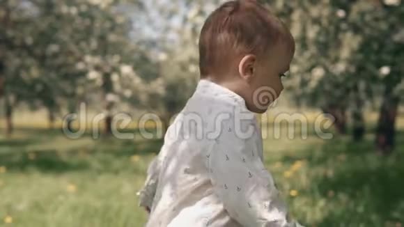 孩子在绿草上奔跑小男孩在城市公园的草地上迈出第一步视频的预览图