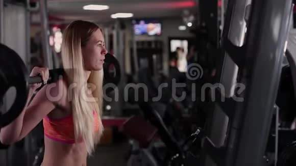 非常漂亮和健身模型训练腿与运动杠铃在健身房视频的预览图