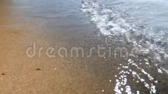 阳光明媚的一天沙滩上小海浪的4k特写镜头视频的预览图