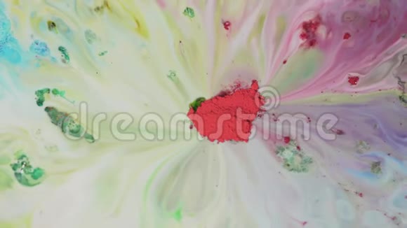 彩色粉末涂料在水中混合中间的红色粉末的特写可以吸收牛奶表面五颜六色的洗液视频的预览图