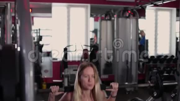 非常漂亮和健身模型训练腿与运动杠铃在健身房视频的预览图