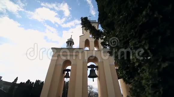 在大风中阳光明媚的日子里教堂的钟声风摇动钟楼附近的树木索内奇卡在闪耀视频的预览图