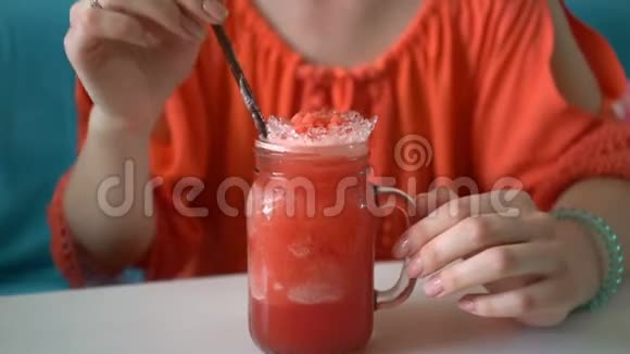 年轻漂亮的女人喝着新鲜的热带西瓜奶昔视频的预览图