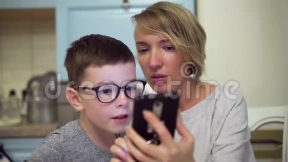 母亲和儿子惊奇地看着智能手机屏幕视频的预览图