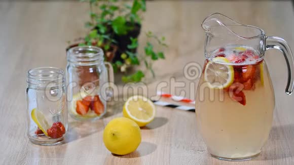 柠檬与草莓柠檬和冰在一个玻璃罐子视频的预览图