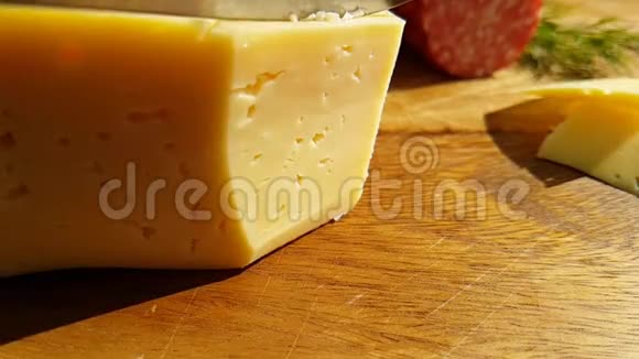 刀在木板上切片奶酪慢镜头拍摄绿色香肠腊肠视频的预览图