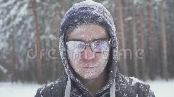 冬天的森林里一个戴着眼镜的冻人在一场暴风雪之后浑身是雪视频的预览图