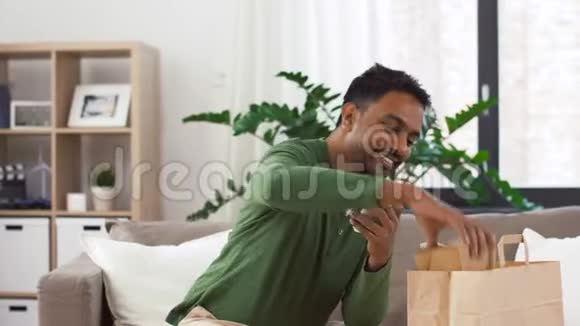 印度男人在家里检查外卖食品视频的预览图
