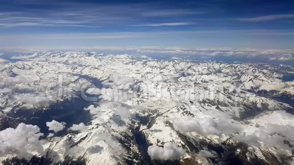 从蓝天雪峰和白云的飞机窗口观看空中景色视频的预览图