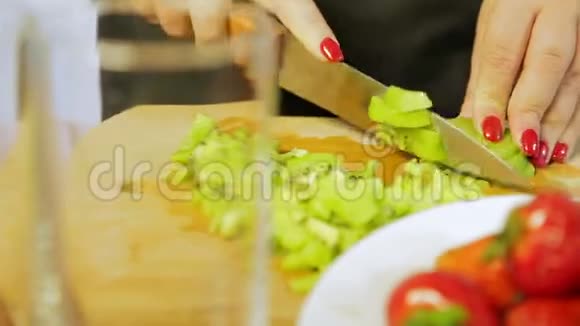 女人把成熟的猕猴桃切成薄片把刀放在木板上视频的预览图