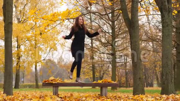 秋日公园的枫树上翩翩起舞的女子视频的预览图