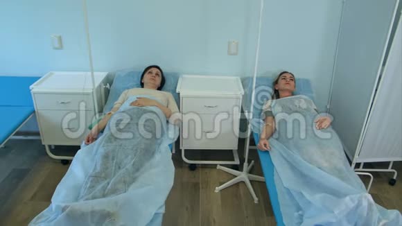 男医生检查两名女性病人在床上点滴视频的预览图