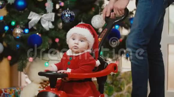 一个穿着圣诞服的小女孩在玩具车里翻滚视频的预览图