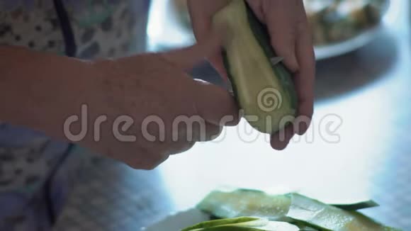 特写镜头一位老妇人的手在一片薄木桩黄瓜的帮助下视频的预览图