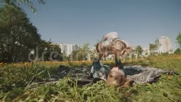 母亲和女儿躺在草坪上家庭在户外公园玩得开心视频的预览图