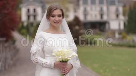 把漂亮的新娘关在外面穿着优雅的婚纱扮成摄像机的迷人女人视频的预览图