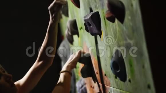 一个登山者的特写在室内的石墙上爬雕塑手固定在终点练习是视频的预览图