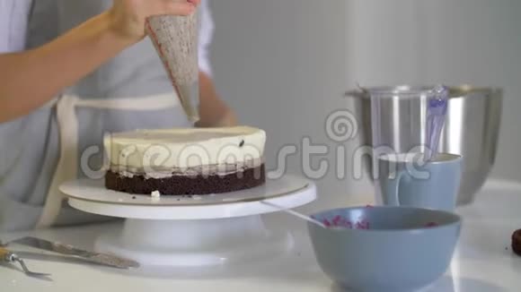 厨师挤压奶油巧克力蛋糕上的糖霜白色蛋糕上覆盖着巧克力和奶油巧克力蛋糕装饰糕点C视频的预览图